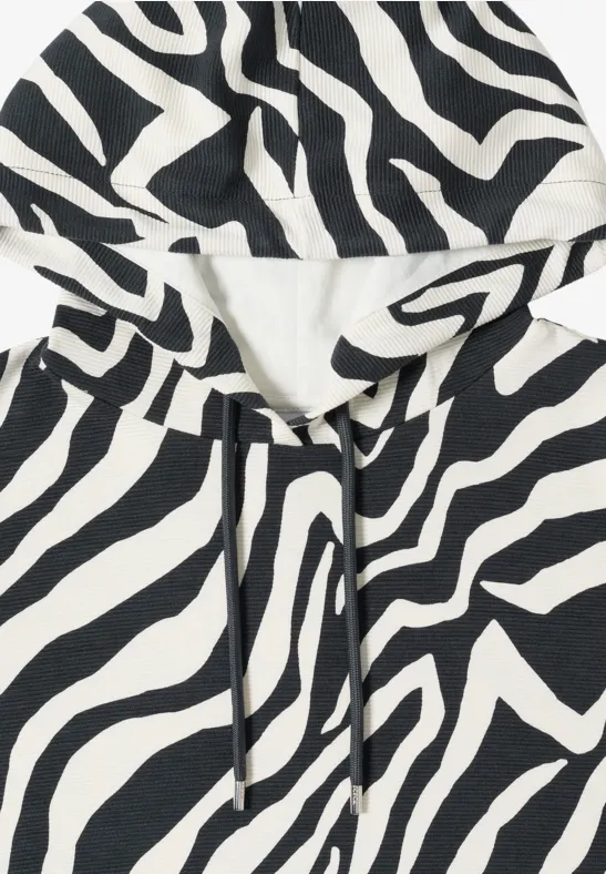 Weicher Kapuzenpullover in Zebramuster (schwarz-weiß) mit Kordelzug.