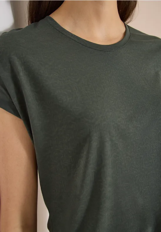 Close-up van een donkergroen T-shirt met korte mouwen gedragen door een persoon