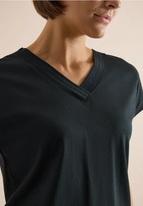 Vrouw draagt een zwart T-shirt met V-hals