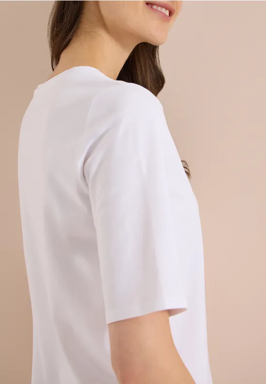 Zijaanzicht van een simpele witte t-shirt met halflange mouwen bij een vrouw voor een beige achtergrond.