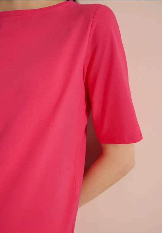 Een roze T-shirt met korte mouwen gedragen op de bovenlichaam van een persoon.