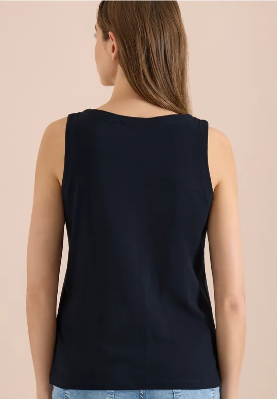 Frau von hinten in dunkelblauem ärmellosem Oberteil, lange braune Haare, neutraler Hintergrund.