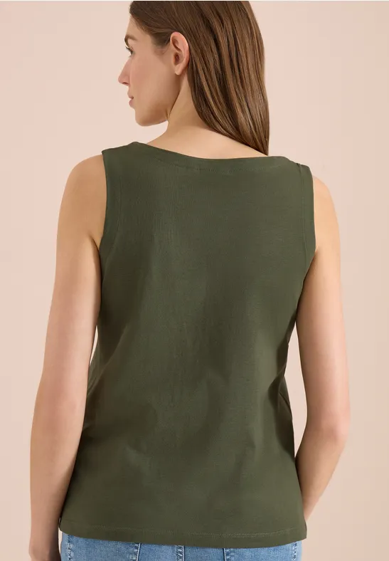 Rückansicht einer Person mit olivgrünem Top und Jeans.