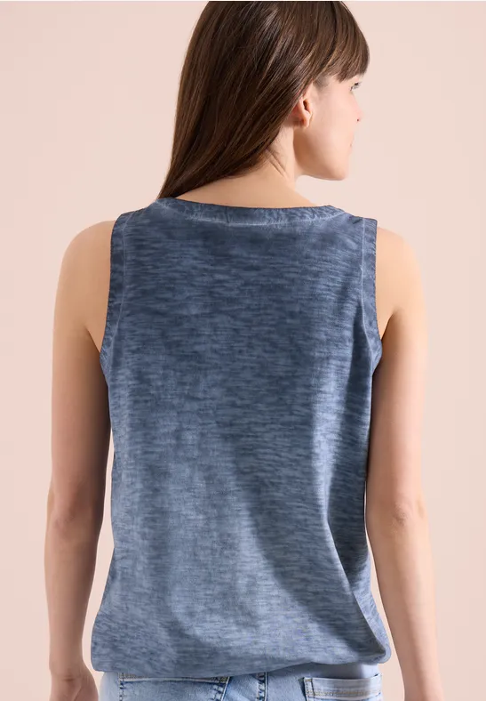 Frau von hinten in ärmellosem, grau-blau meliertem Top vor hellem Hintergrund.