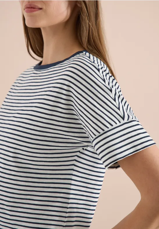 Frau trägt weißes T-Shirt mit navyblauen Querstreifen und halblangen Ärmeln.