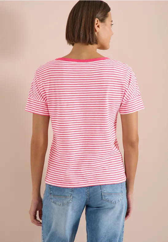 Rückenansicht einer Person in rosa-weiß gestreiftem T-Shirt und hellblauen Jeans vor beigem Hintergrund.