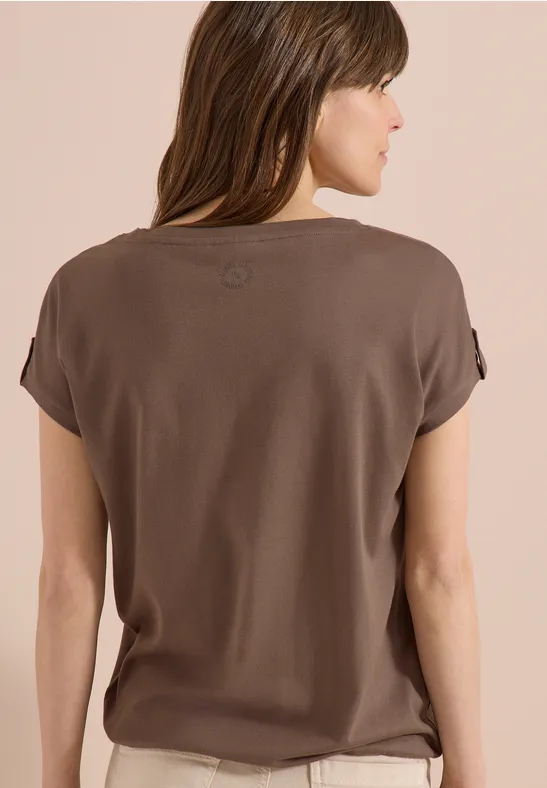 Femme vue de dos portant un t-shirt marron simple, visage flou.