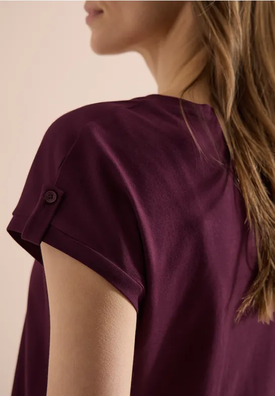 T-shirt femme violet foncé avec revers de manche et bouton, vue de côté et de dos.