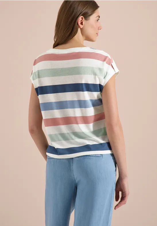 Vrouw van achteren in pastel gestreept shirt en lichtblauwe spijkerbroek.