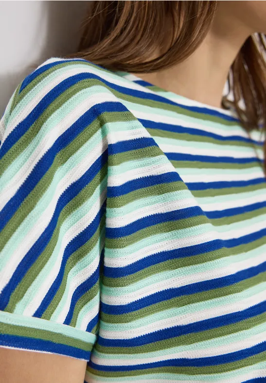 Vrouw in een kortmouwig gestreept shirt in groen, blauw en wit.