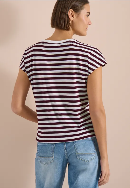 Femme de dos portant un t-shirt rayé et un jean bleu.