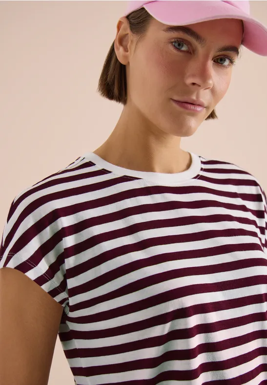 Buste d'une personne portant un T-shirt rayé blanc et bordeaux, fond neutre.