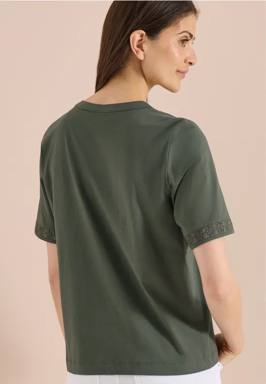 Rugaanzicht: vrouw draagt losse, donkergroene T-shirt met korte mouwen, neutrale achtergrond.