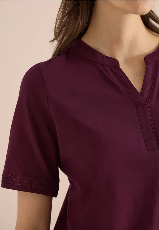 Damesblouse in bordeaux, korte mouwen, V-hals met split en fijne opengewerkte borduurring aan de mouwzoom.