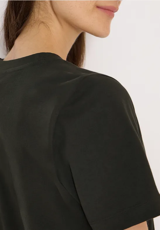 Gedeeltelijke weergave van een persoon in een donker T-shirt, rug en kin in profiel.