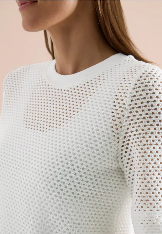 Wit, luchtig gebreid topje met rond halsgat en subtiel ajourpatroon.