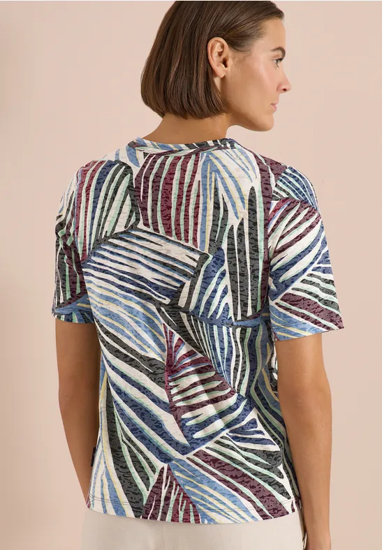 Achteraanzicht van een vrouw in een kort mouwt-shirt met abstracte strepen en een kleurrijk patroon.