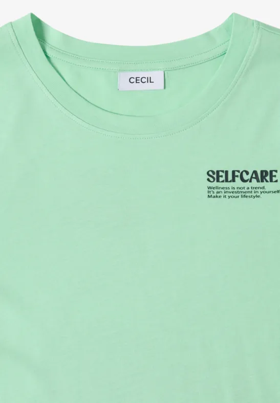 Pastelgroen T-shirt met CECIL-label en SELFCARE-opdruk met slogan op de borst.