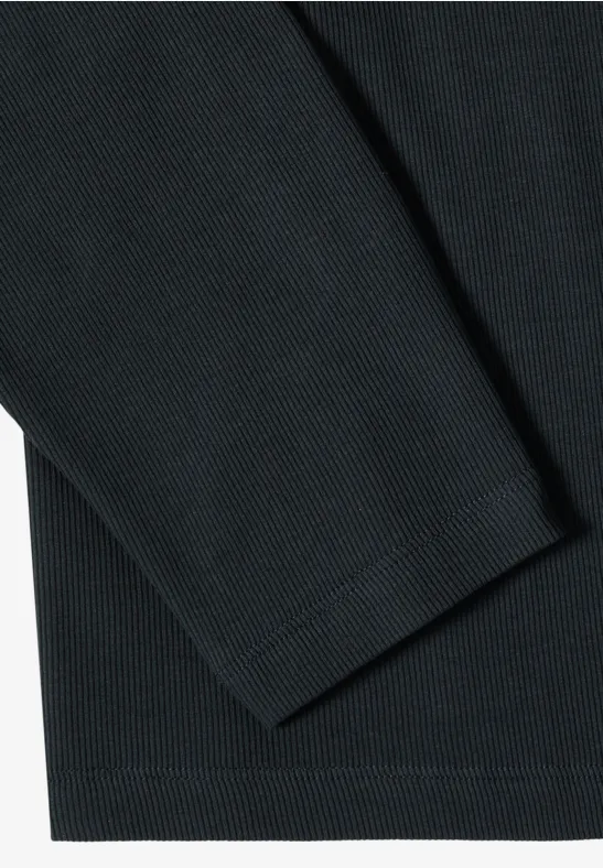 Close-up van een gestructureerde zwarte stof, deel van een langarmshirt.