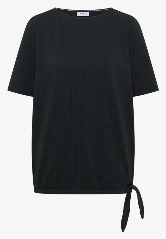 Zwart damesshirt met reliëf stippenpatroon, korte mouwen en zijknoopdetail bij de zoom.