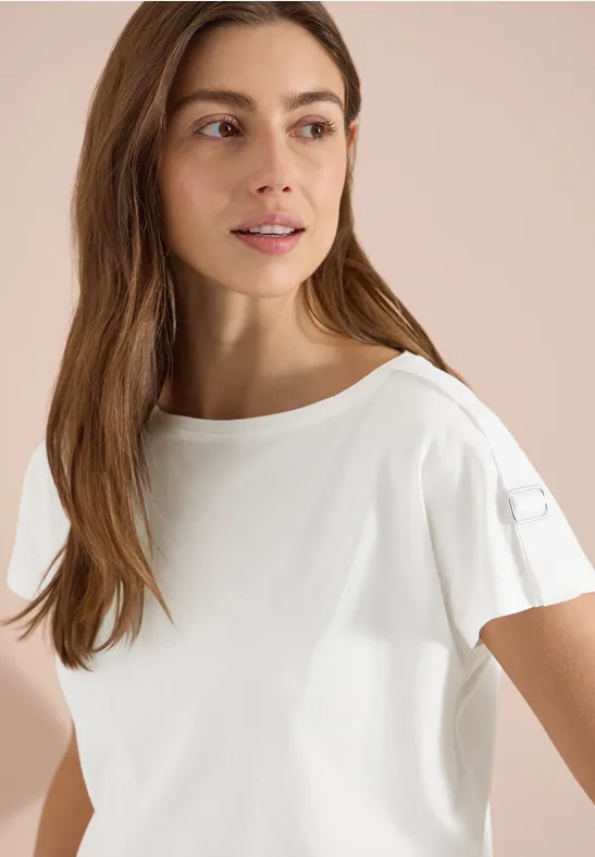 Eine Person trägt ein schlichtes weißes T-Shirt mit Rundhalsausschnitt und kurzen Ärmeln.