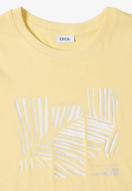 T-shirt jaune pastel avec motif abstrait de feuilles de palmier blanches et logo CECIL au col.
