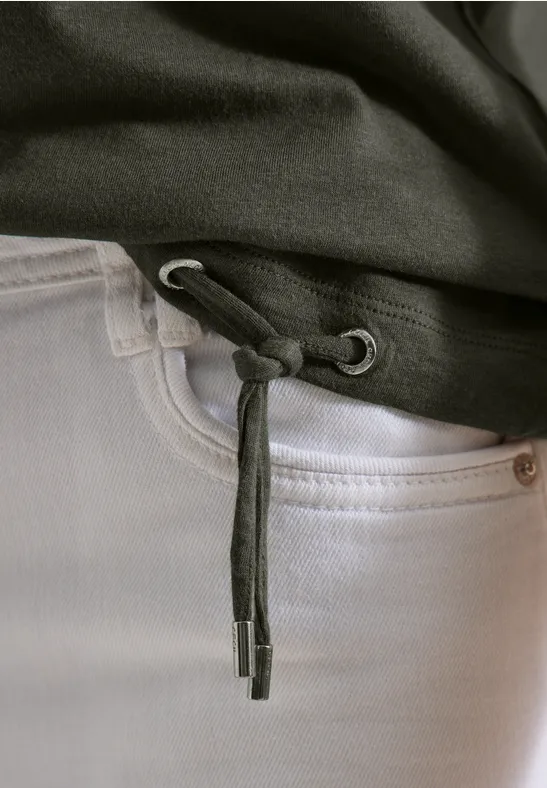 Close-up von weißen Jeans und schwarzem Hoodie mit gebundener Kordel am Saum