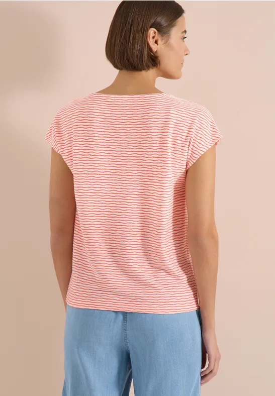 Femme de dos portant un t-shirt à rayures rouges et blanches et un jean bleu clair.