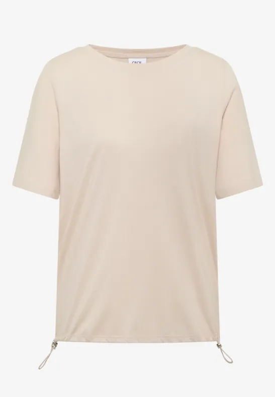 Ein schlichtes, beigefarbenes T-Shirt mit kurzen Ärmeln und Kordelzug am Saum.