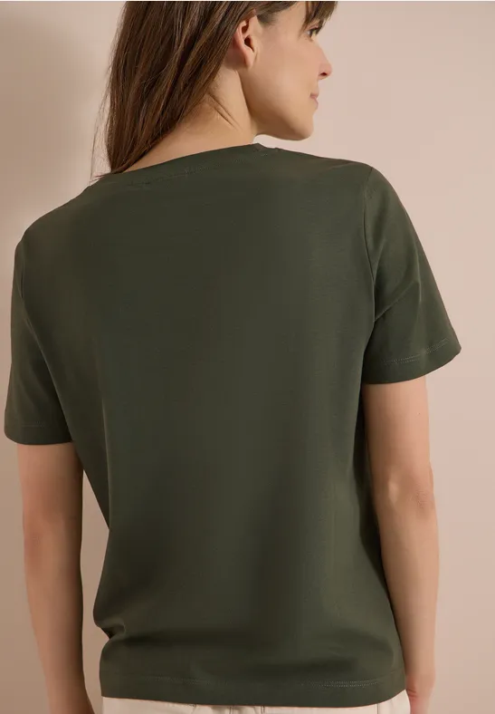 Rückansicht einer Frau in einem dunkelgrünen T-Shirt.