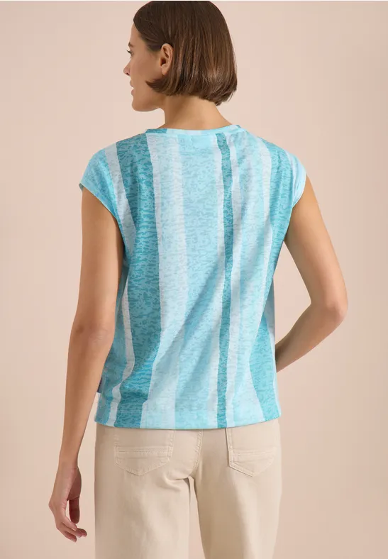 Femme vue de dos portant un chemisier ample à rayures turquoise et blanc, manches courtes.