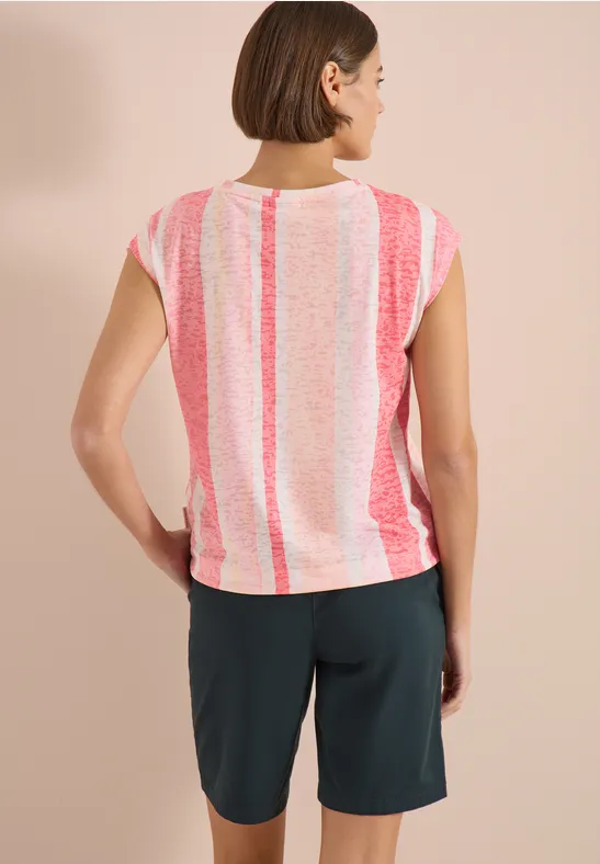 Vue de dos d’une femme en t-shirt rayé rose et blanc et short foncé sur fond neutre.