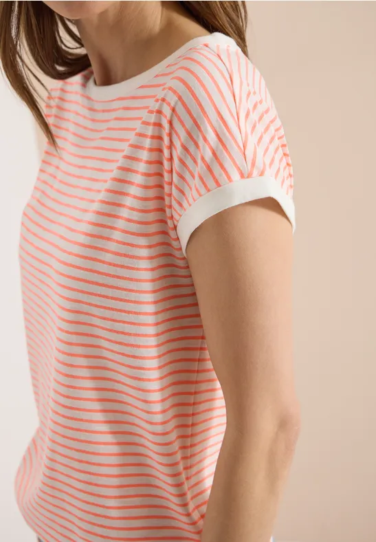 Person trägt weißes, kurzärmeliges T-Shirt mit feinen, horizontalen Korallenstreifen vor beigem Hintergrund.