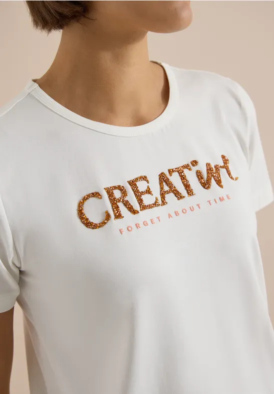 Weiße T-Shirt mit braunem Schriftzug 'CREATIV' und kleinem 'FORGET ABOUT THEM'