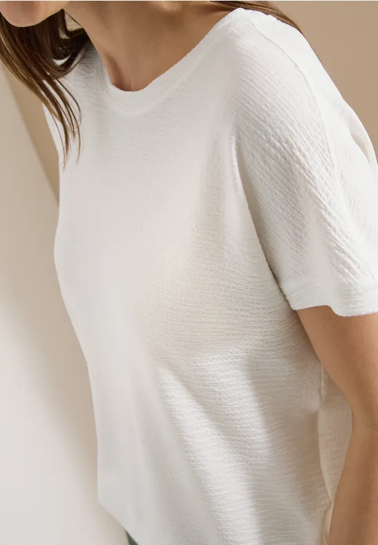 Weißes geripptes Kurzarm-T-Shirt an einer Frau, Seitenansicht.
