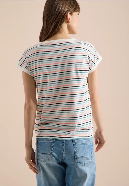 Rückansicht einer Frau in gestreiftem T-Shirt und Jeans vor hellem Hintergrund.