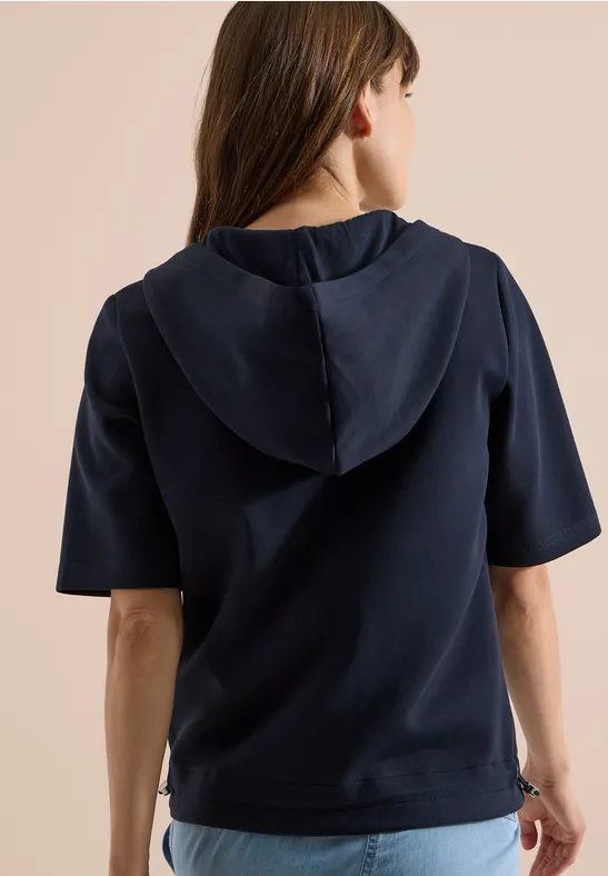 Rückenansicht einer Person in marineblauem kurzärmeligem Kapuzenpullover.