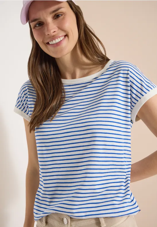 Frau im blau-weiß gestreiften T-Shirt mit kurzen Ärmeln vor hellem Hintergrund, Oberkörper sichtbar.