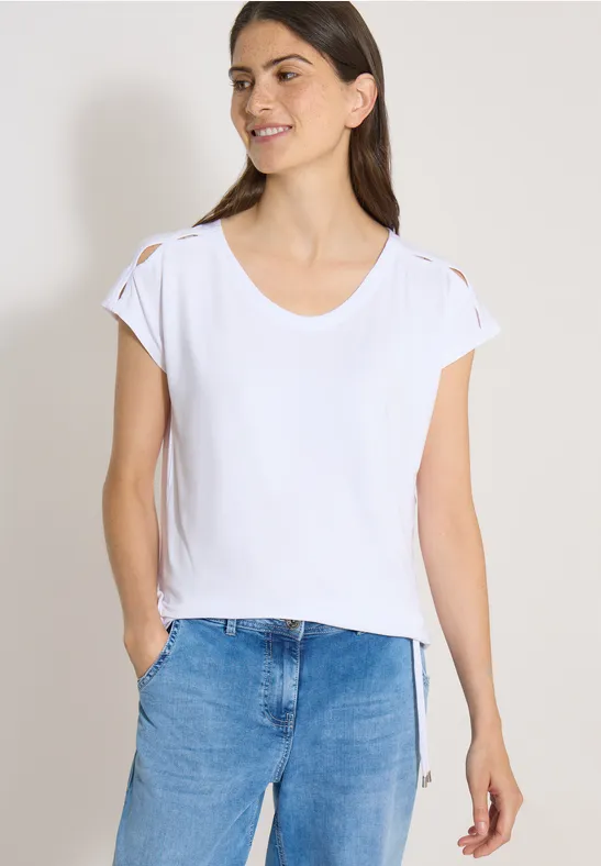 Femme en t-shirt blanc simple à manches retroussées et en jean bleu.