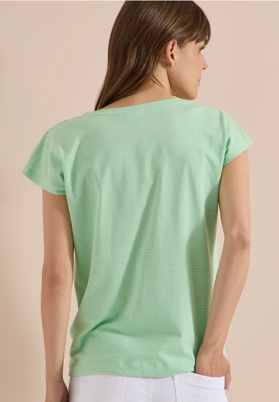 Eine Frau in einem mintgrünen T-Shirt, von hinten gezeigt.