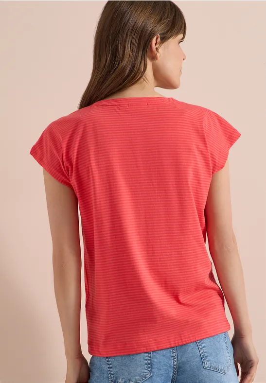 Frau von hinten in rotem, gestreiftem T-Shirt und Jeans.