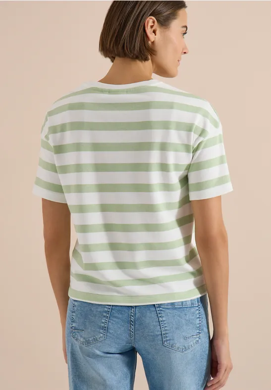 Vrouw van achteren in een groen-wit gestreept t-shirt en blauwe spijkerbroek