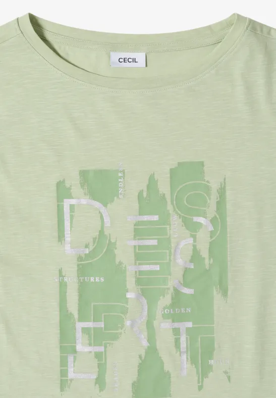Pastellgrünes T-Shirt mit abstraktem Schriftzug und Muster vorn.