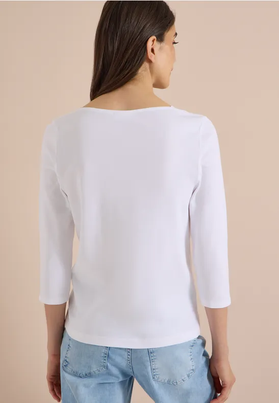 Frau von hinten in weißem Shirt mit 3/4-Ärmeln und hellblauen Jeans.