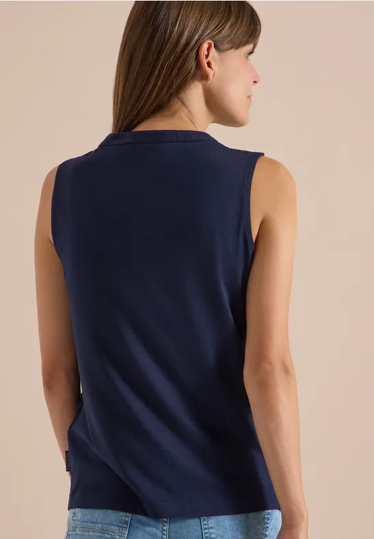 Vrouw van achter in een donkerblauw mouwloos topje, halflange bruine haren
