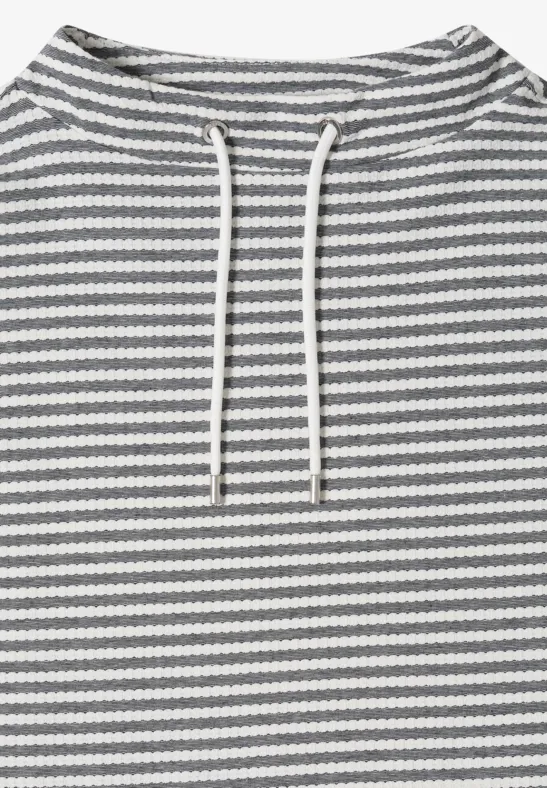 Een hooded trui met grijs-witte horizontale strepen en witte trekkoorden.