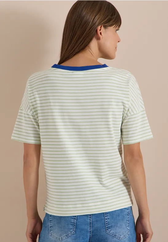 Frau von hinten in weiß-grün gestreiftem T-Shirt mit blauem Kragen und Jeans.