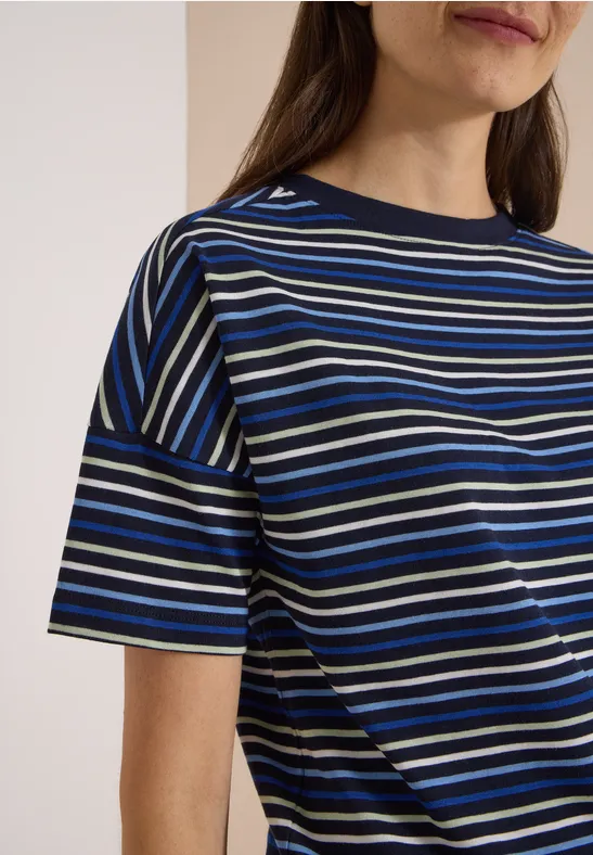 Vrouw draagt shirt met korte mouwen en horizontale blauw-wit-zwarte strepen.