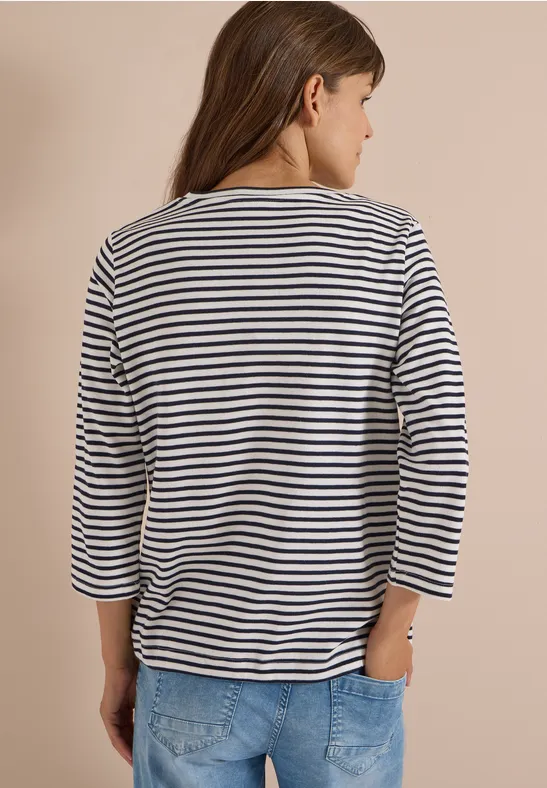 Frau von hinten in gestreiftem Shirt und Jeans.