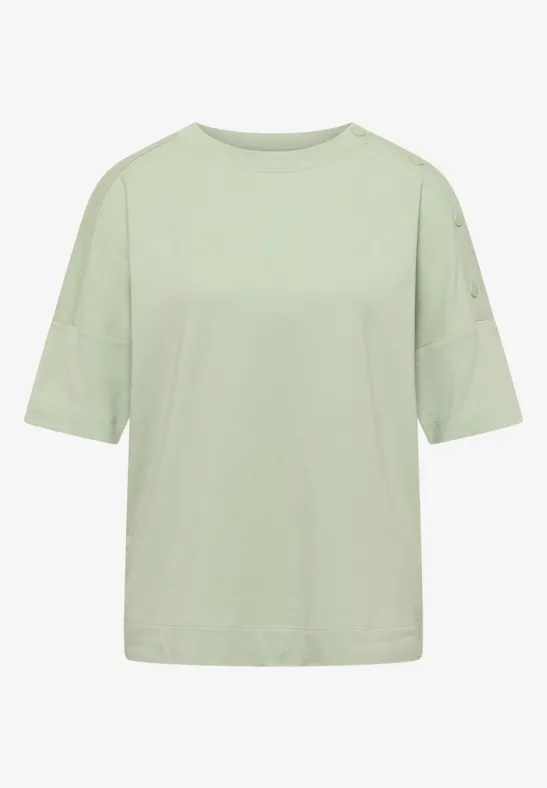 T-shirt ample de couleur vert pastel clair, manches courtes, col rond, style sobre et moderne.
